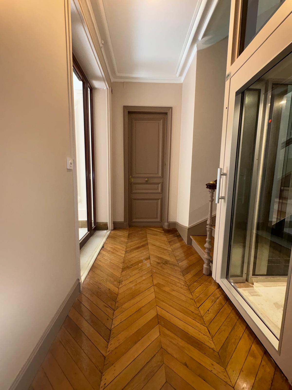 Couloir de copropriété après rénovation avec parquet