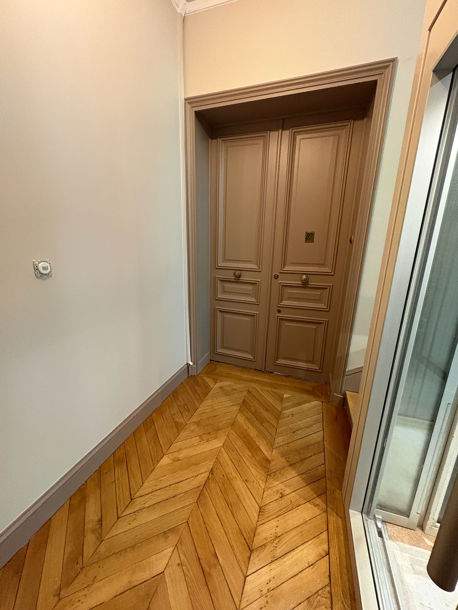Couloir de copropriété après pose du parquet et rénovation des finitions